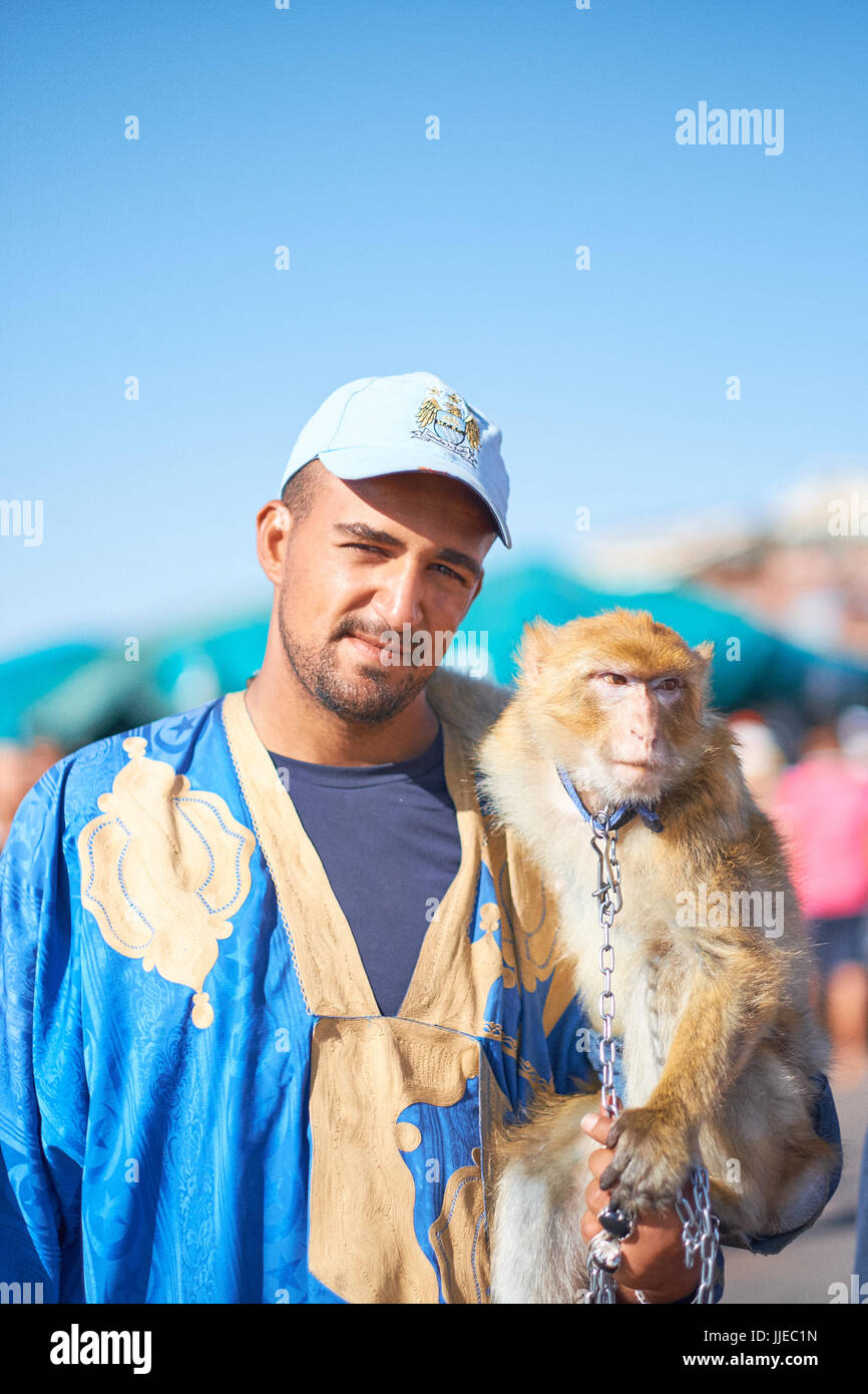 Trainer with monkey on a chain in Place Djemaa el Fna square marketplace in  Marrakech Morocco Stock Photo - Alamy
