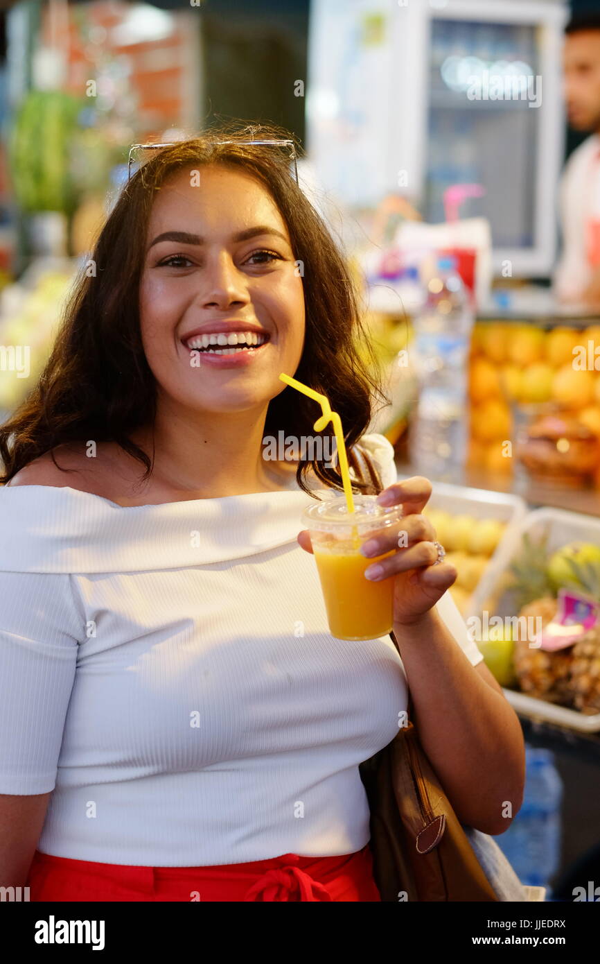 attractive lady drinking a orange juice Marrakech medina,Morocco