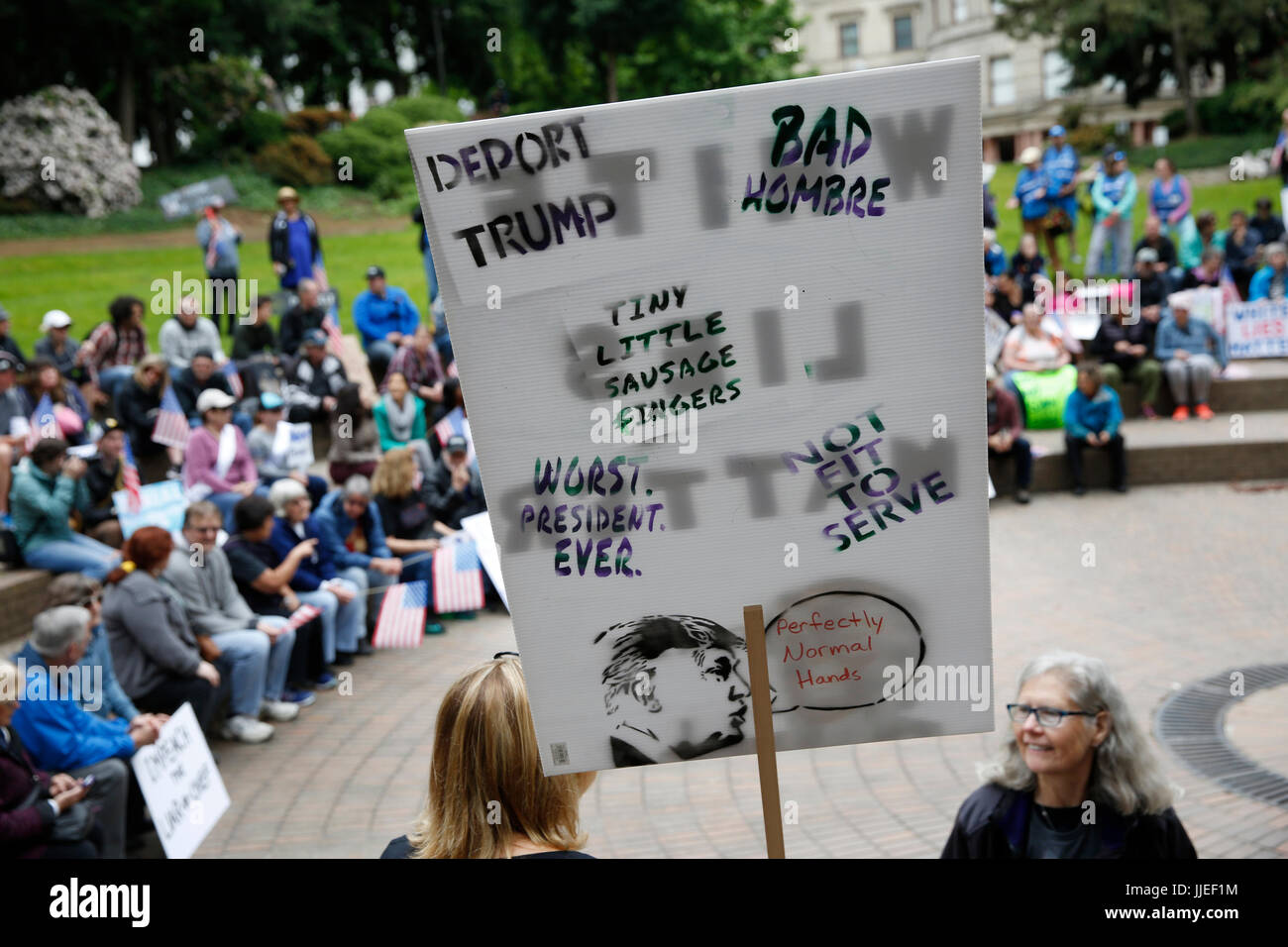 A woman carries a sign while protesting against President Donald Trump at a March for Truth rally on June 3, 2017. Portland, Oregon, United States. Stock Photo