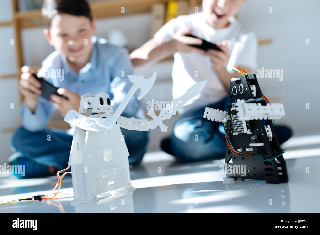 Two cheerful boys fighting with their robots Stock Photo