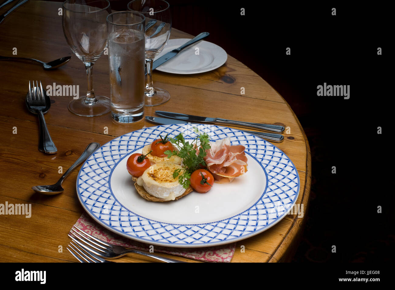 Roast Goat Cheese with Parma Ham and a Balsamic dressing on a white and