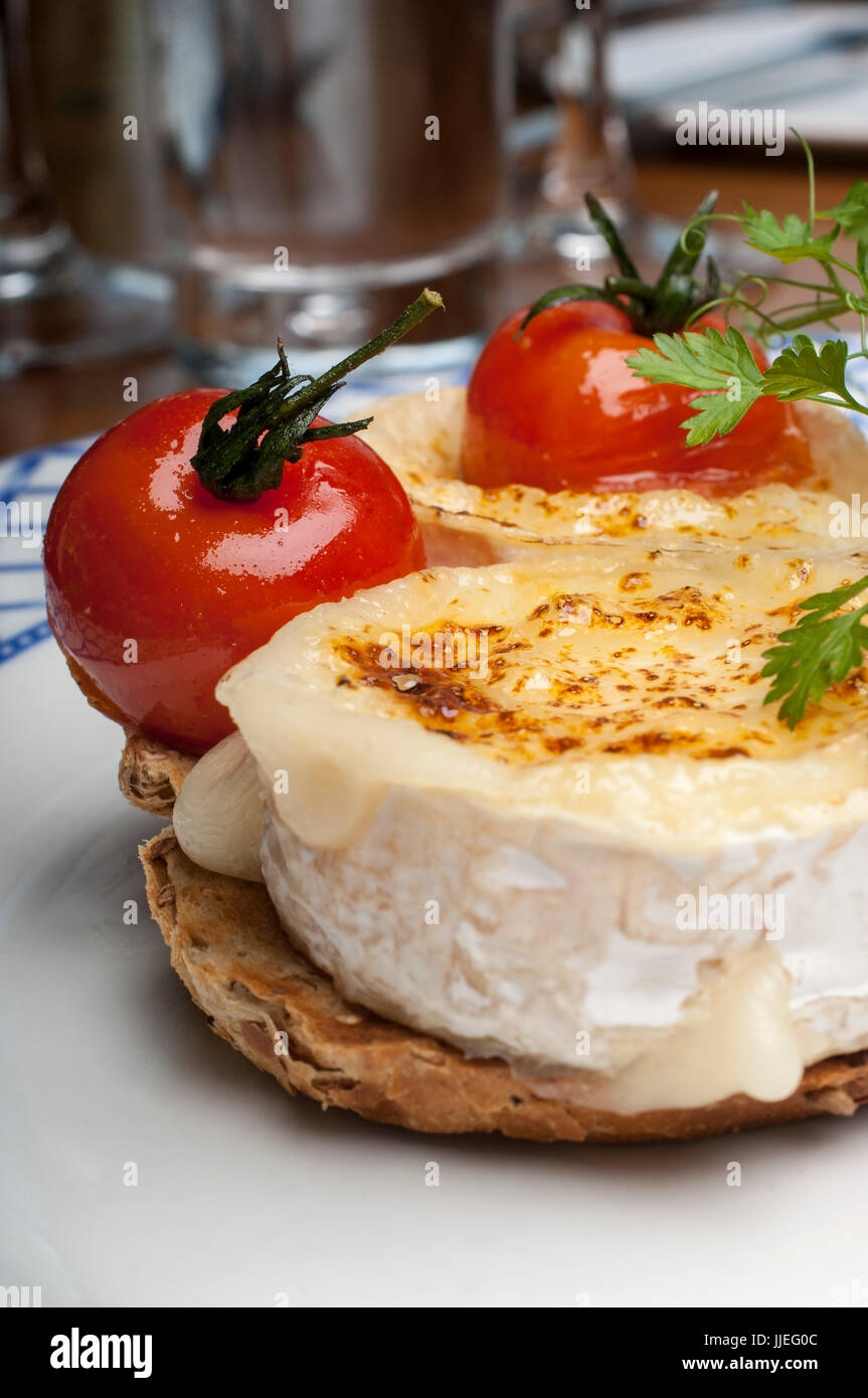 Roast Goat Cheese with Parma Ham and a Balsamic dressing on a white and