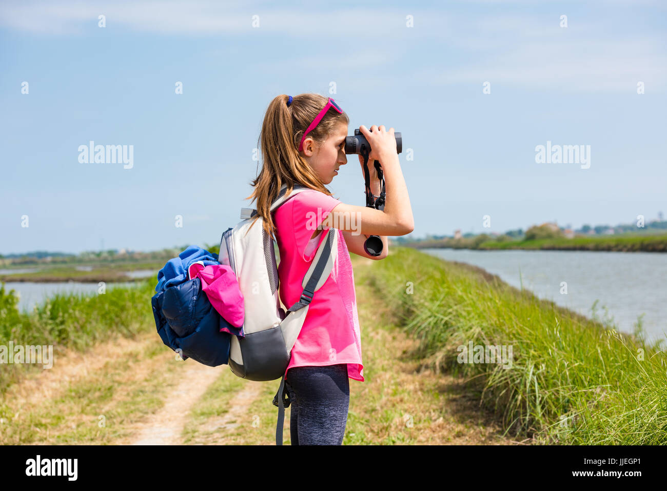 Girl watching the landscape through binoculars Stock Photo