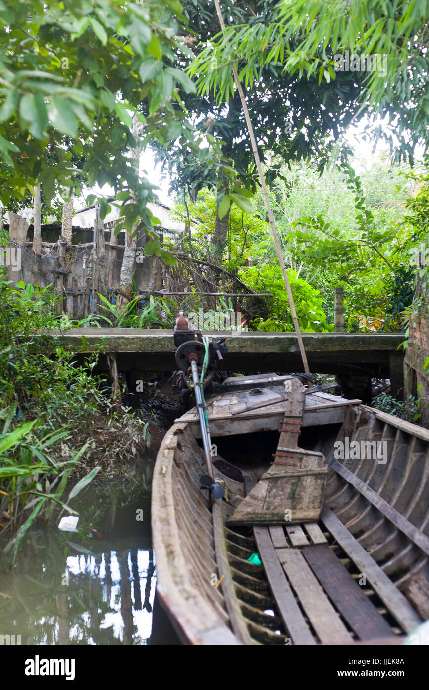 Old Wood home mage engine fisher  boat on Vietnam Mekong Delta Village close to a wooden walkway and village Stock Photo