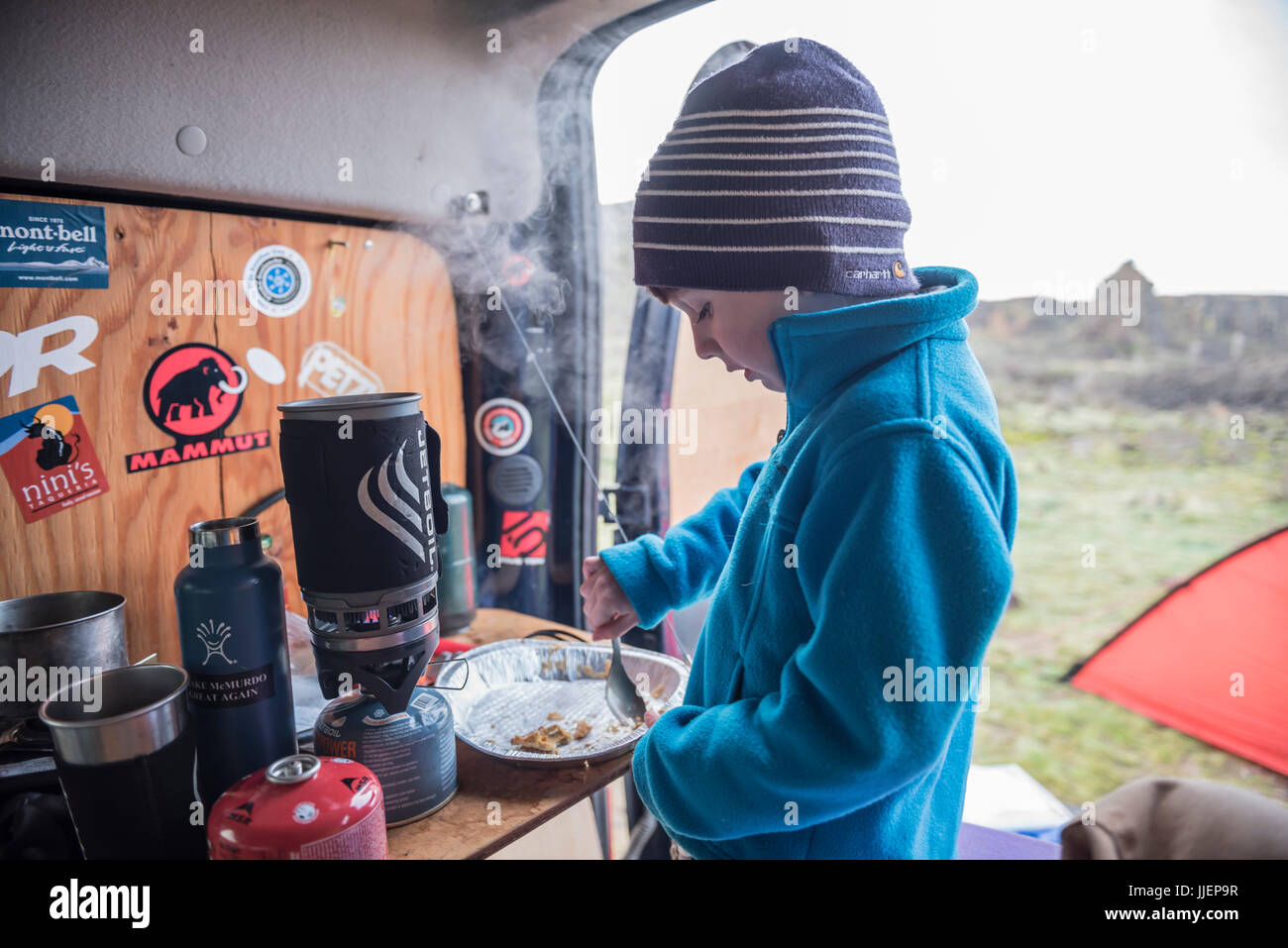 A young boy finishes the last few crumbs of pie crust during a camping trip. Stock Photo