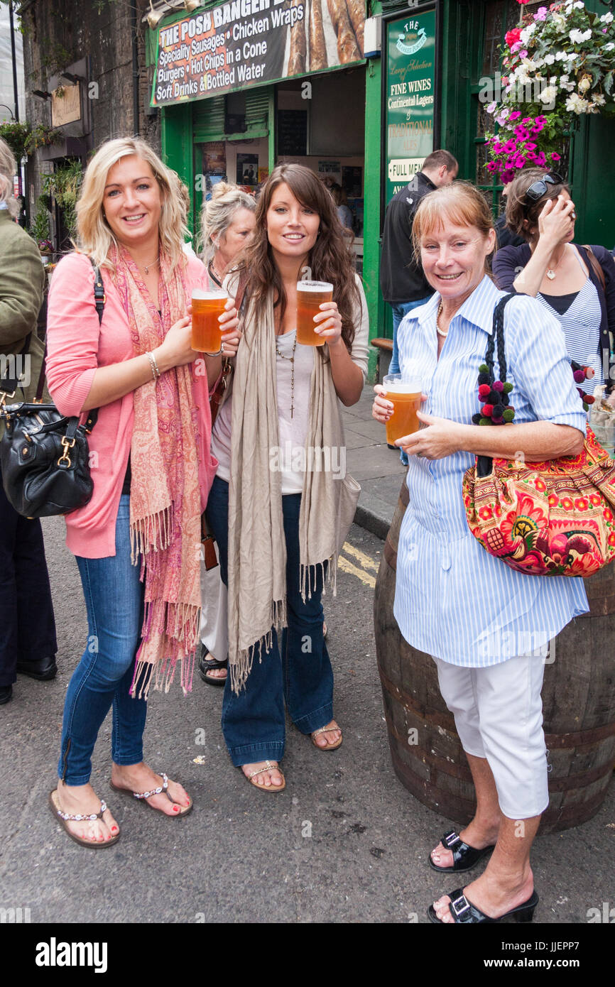 Women drinking pints beer outside the market porter pub hires stock