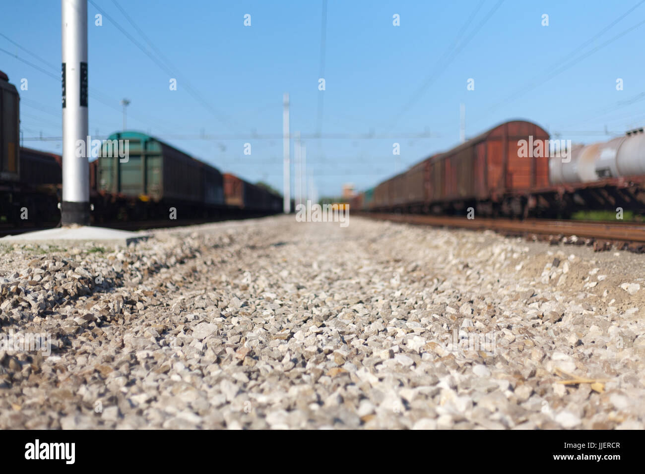 Close Up Narrow shot of a railway stones and rocks close to freight train at the Italian train depot in Bologna Stock Photo