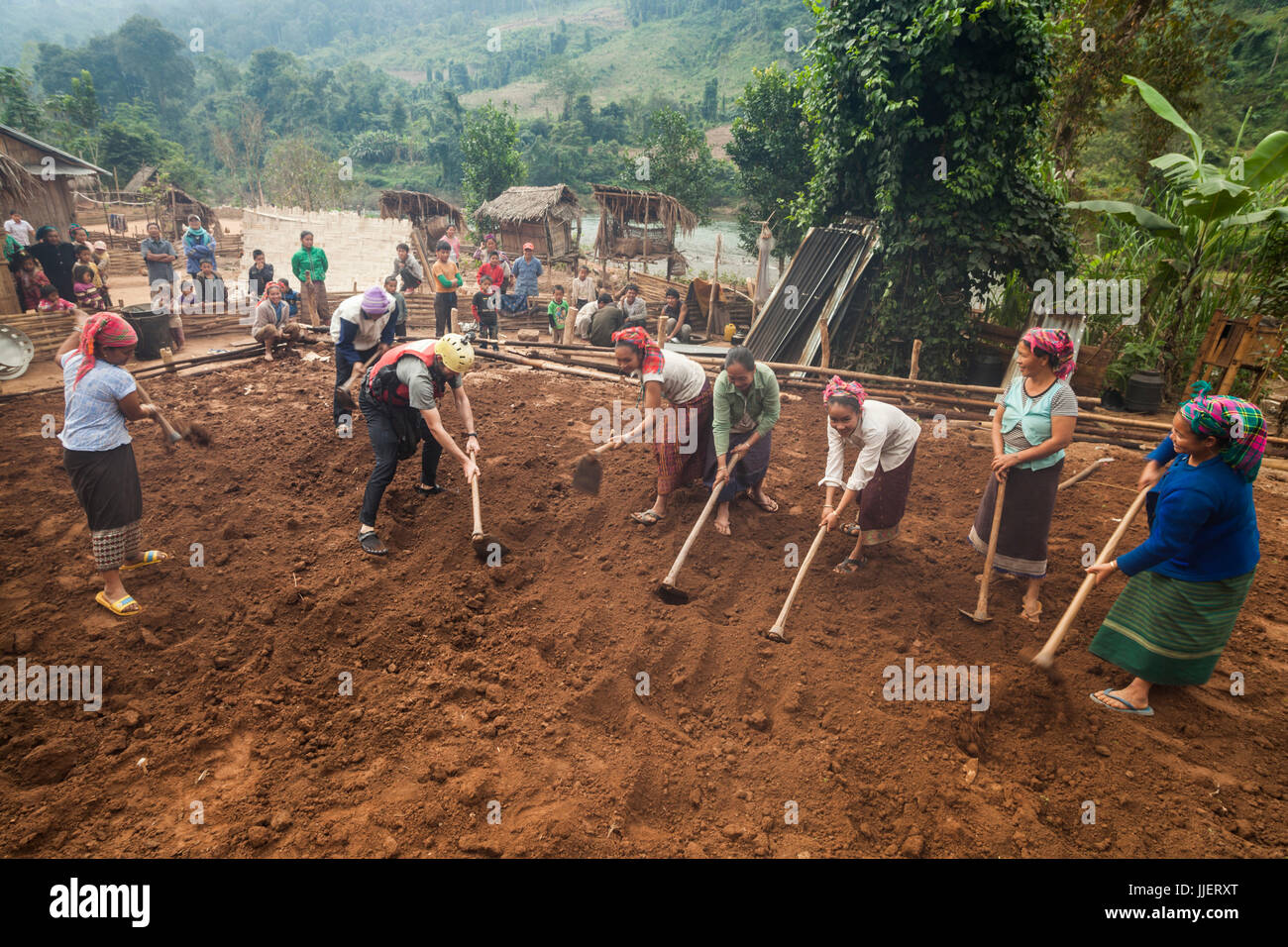 Robert Hahn helps locals grade a flat platform for a new home in Ban Phak Kung, Laos. Stock Photo