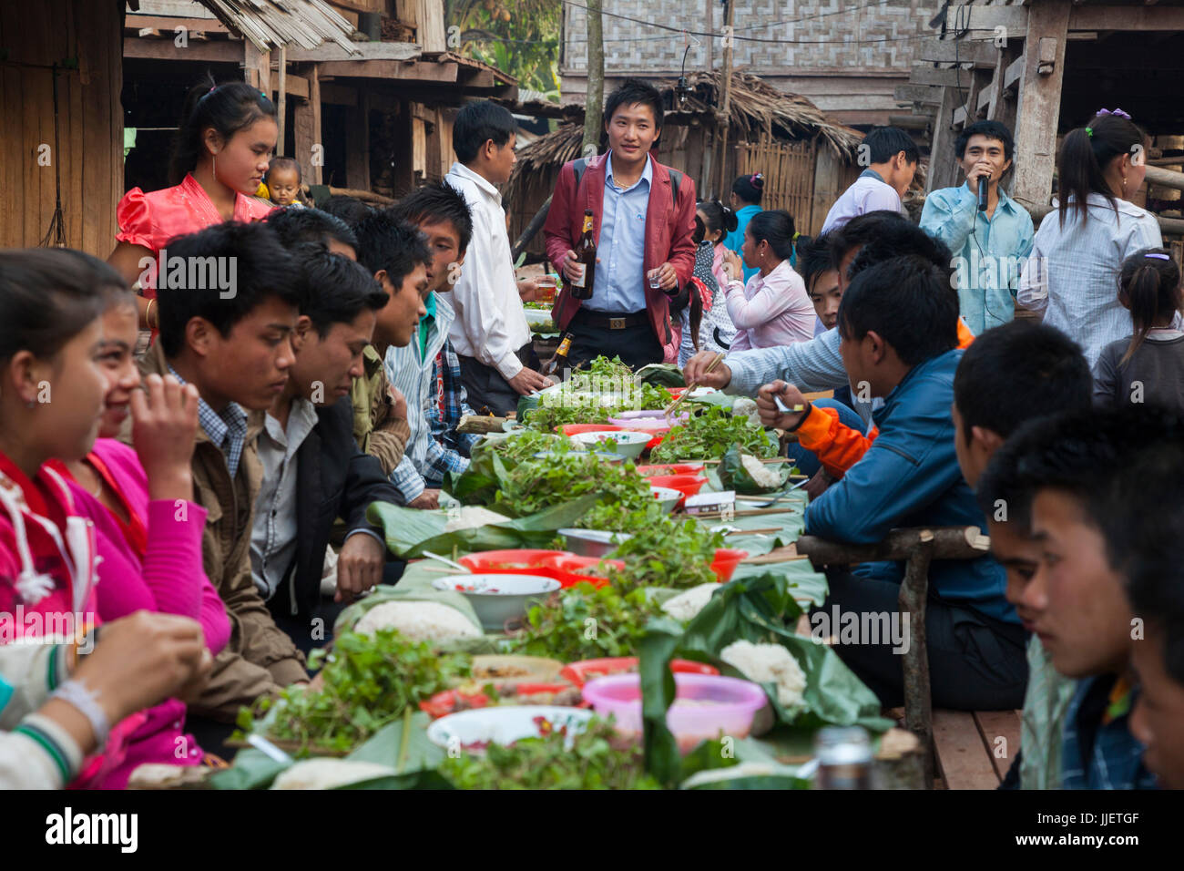 Young adults feast at a wedding celebration in Muang Hat Hin, Laos. Stock Photo