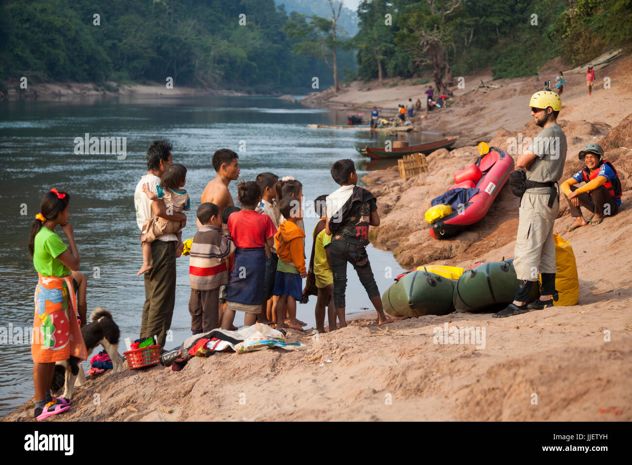 Robert Hahn (front) and Mung attract a large audience of curious locals on the shore of the Nam Ou River in Ban Phu Muang, Laos. Stock Photo