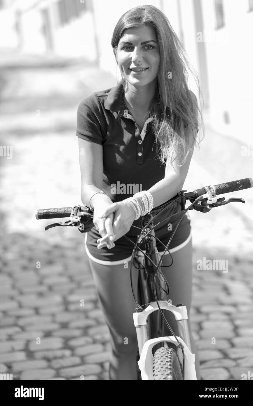 Young brunette woman in shorts riding a sport bike in a sity Stock Photo