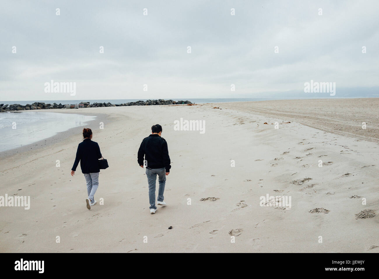 The couple are walking on Venice beach, California. Stock Photo