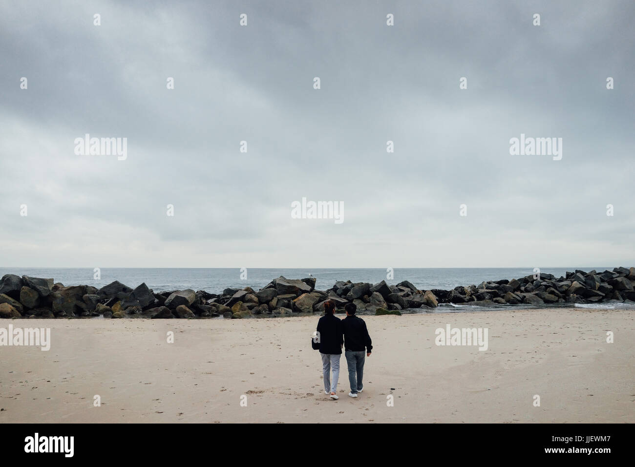 The couple stand and look out from Venice beach, California. Stock Photo