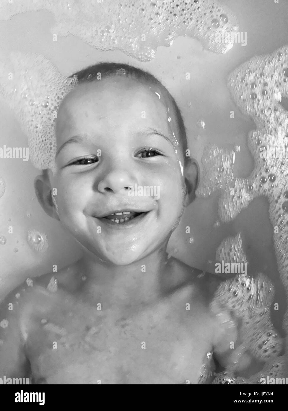 Smiling boy lying in the bath Stock Photo