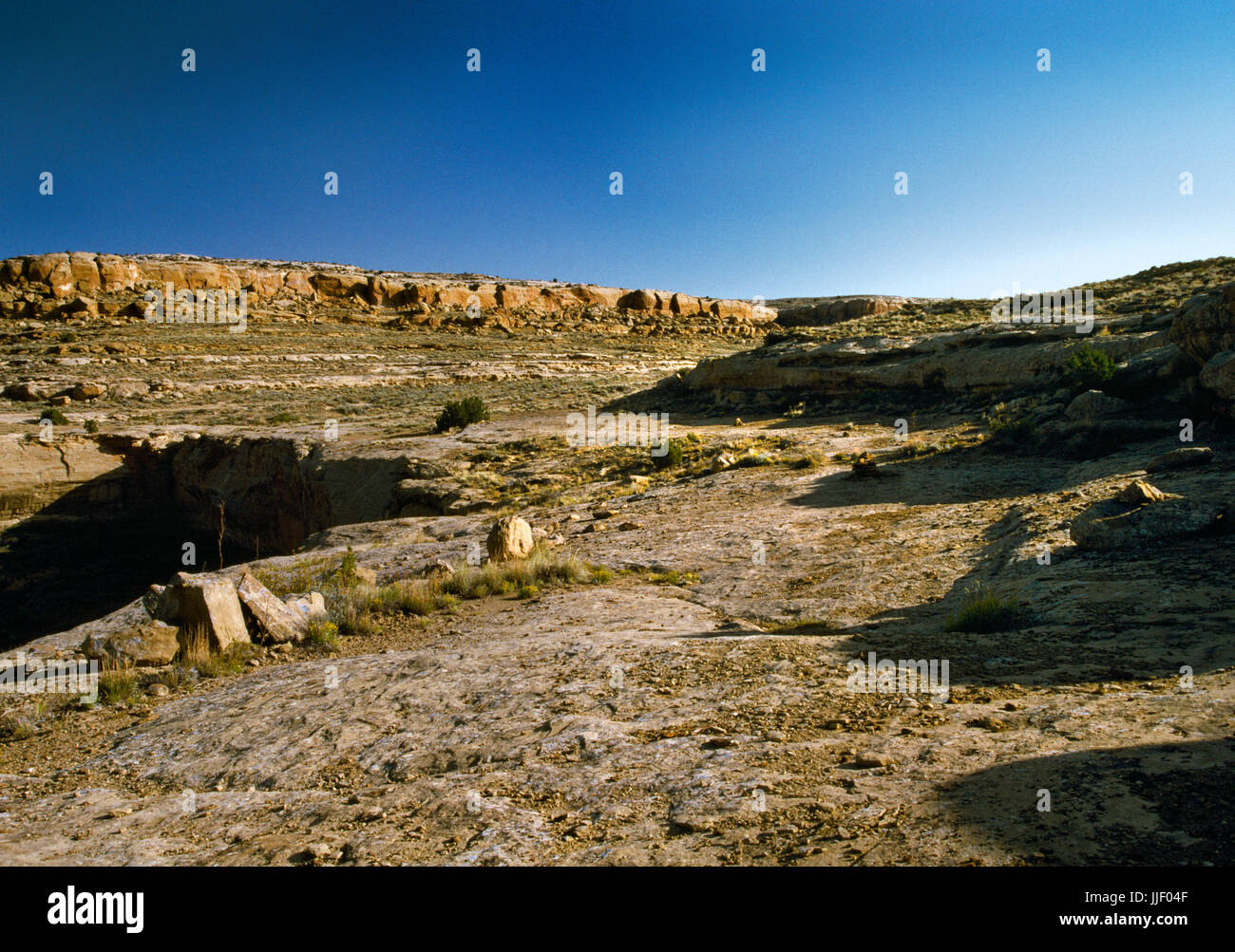 View NNW of part of the Chacoan road system across a cleared section of slickrock on Alto Mesa above Chetro Ketl Pueblo, Chaco Canyon, New Mexico. Stock Photo