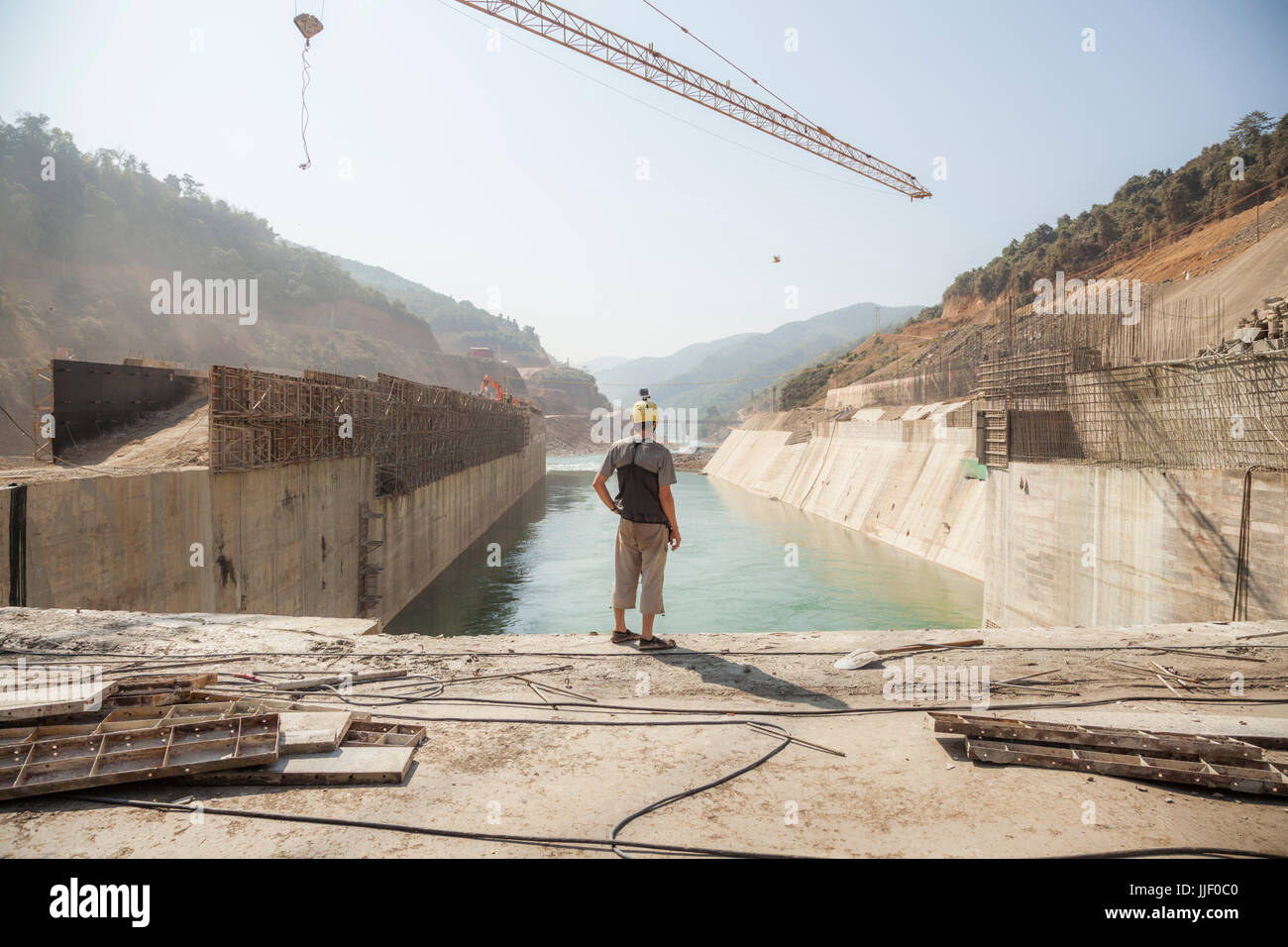 Robert Hahn contemplates the fate of the Nam Ou River in Laos as it flows through a concrete diversion (box) dam at Dam #5. Stock Photo