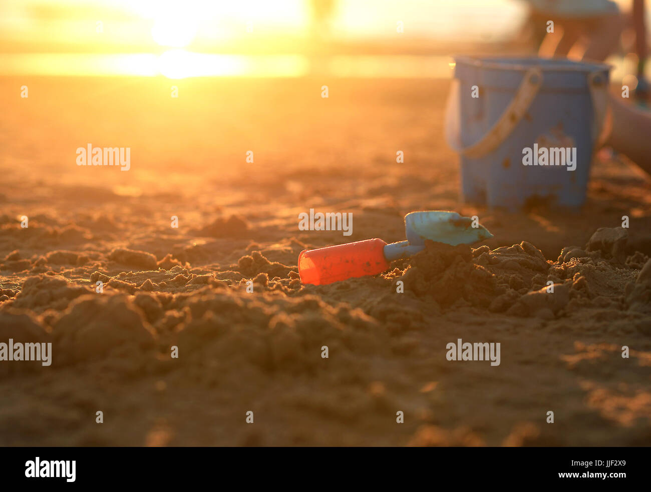 Plastic bucket and spade on the beach at sunset Stock Photo Alamy