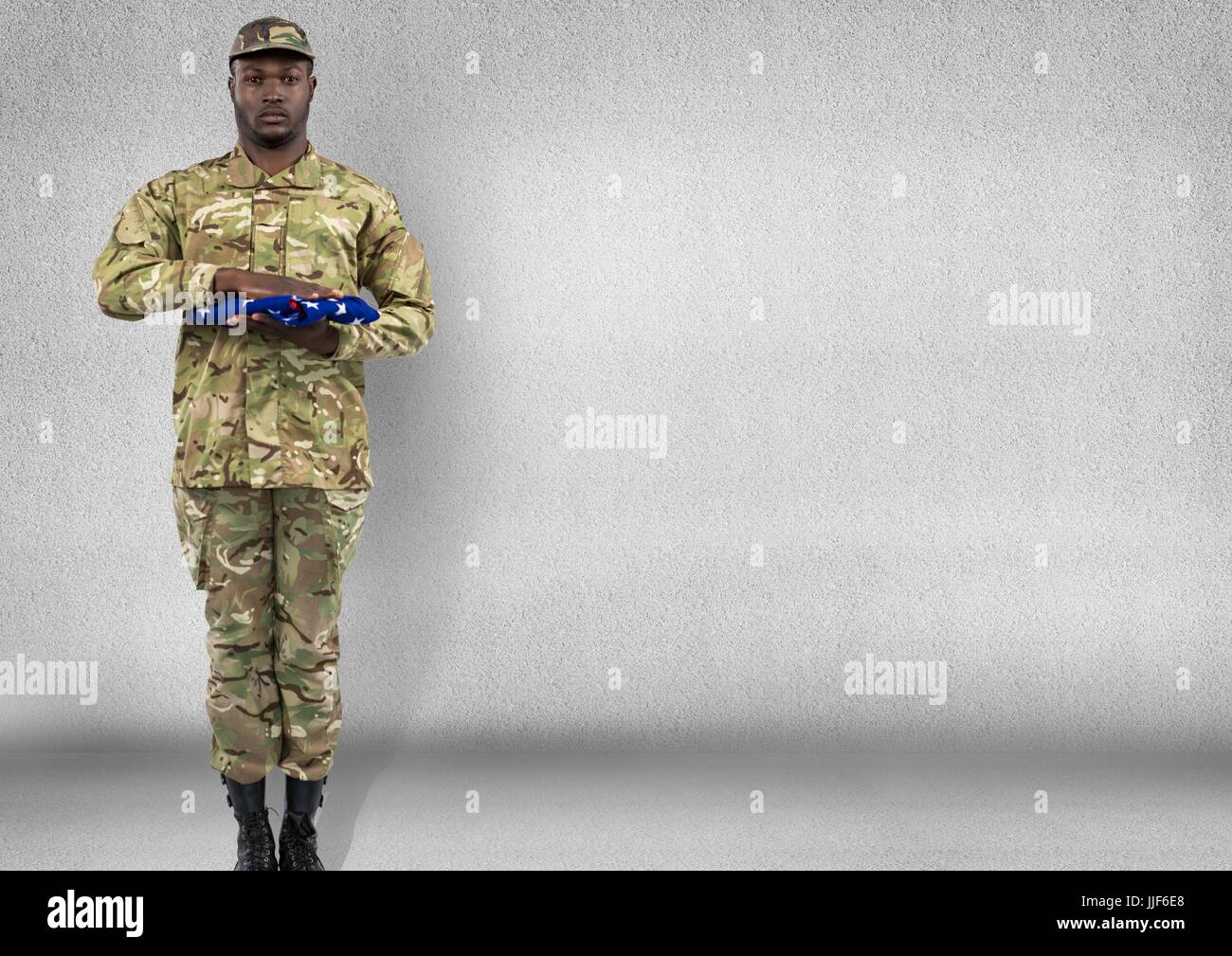 Digital composite of soldier with USA flag in the hands. Concrete room ...