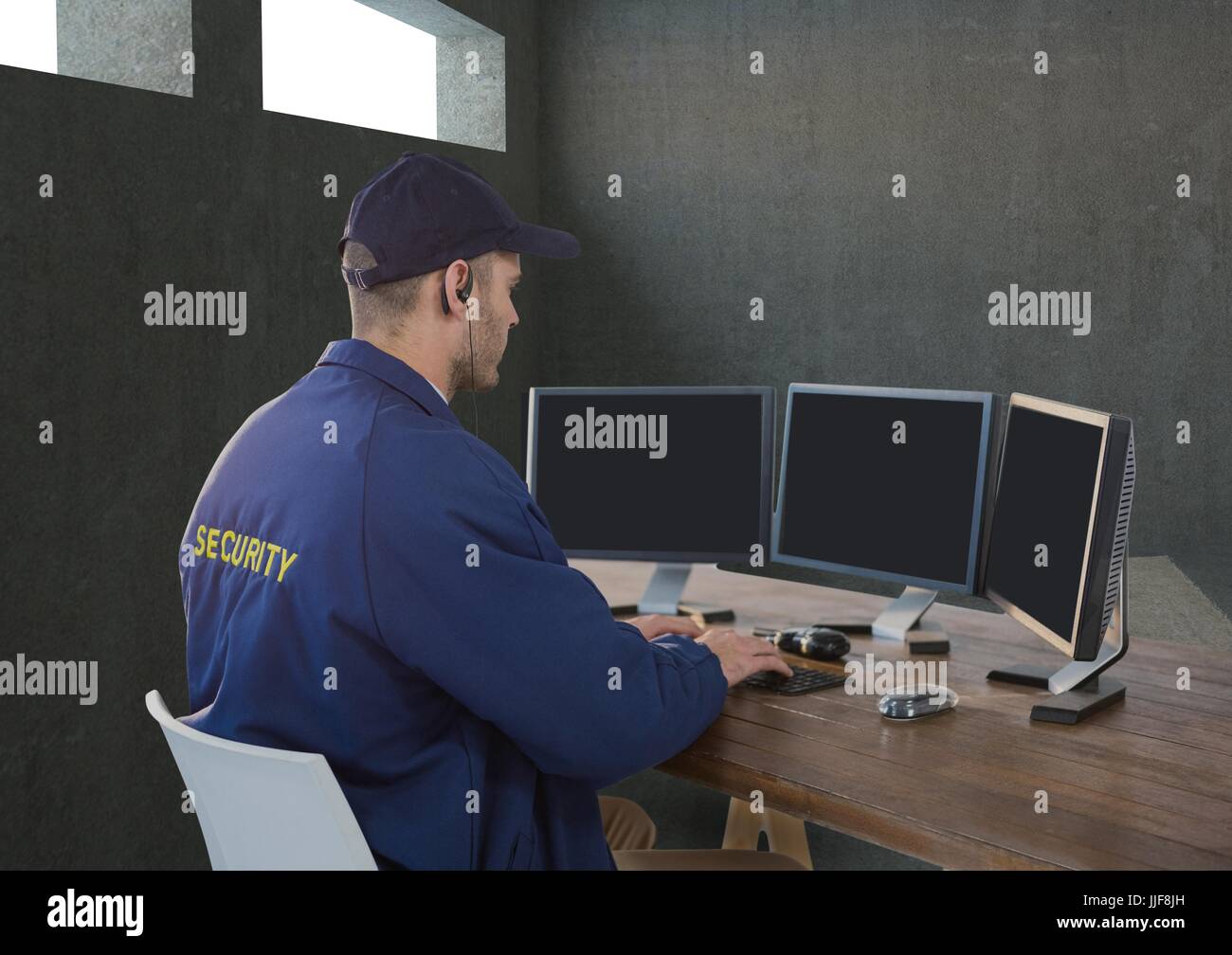 Digital composite of security guard tin his desk with his technology. Stock Photo