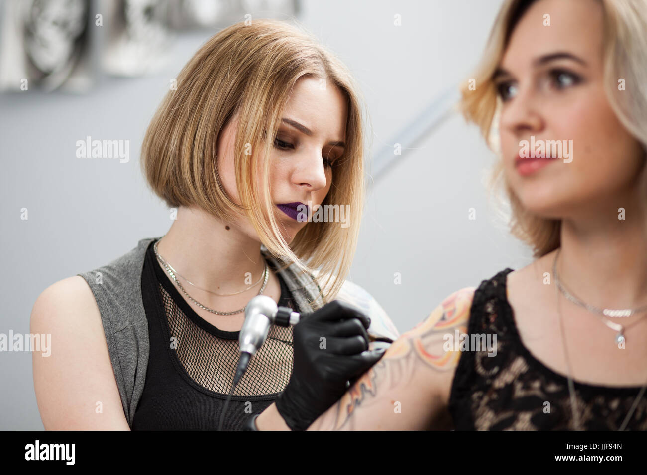 Tattoo artist with a client in a studio Stock Photo