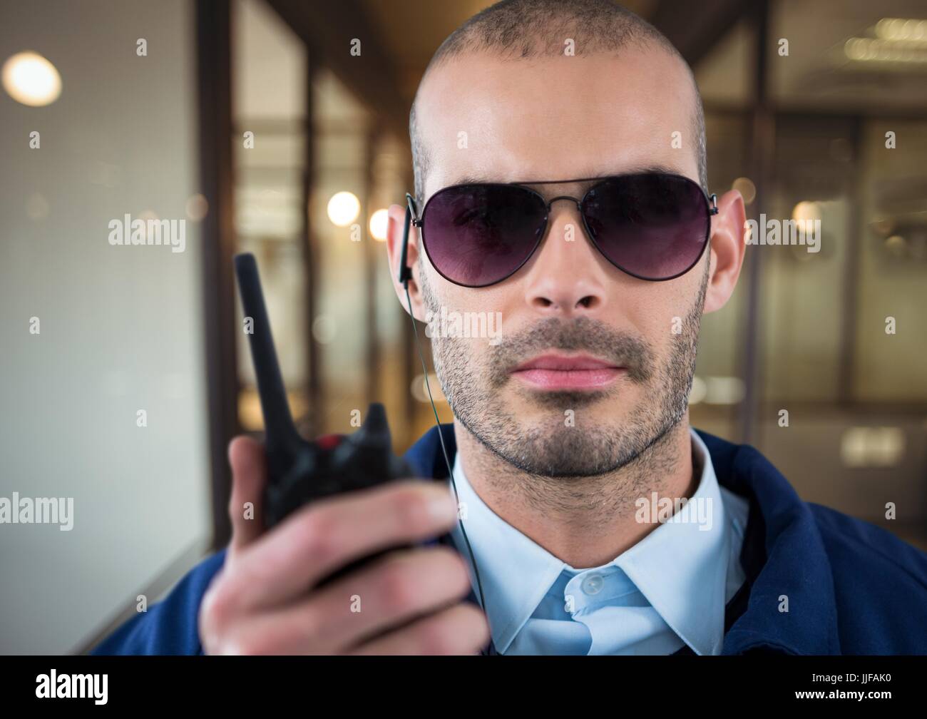 Digital composite of security guard with glasses, headphone and walkietalkie in the office