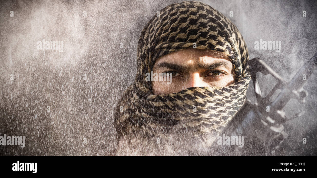 Portrait of soldier with covered face holding rifle against black Stock ...