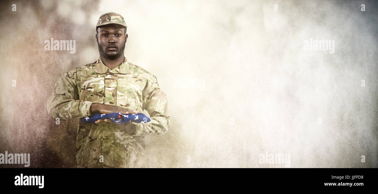 Portrait of soldier holding American flag against dark background Stock ...