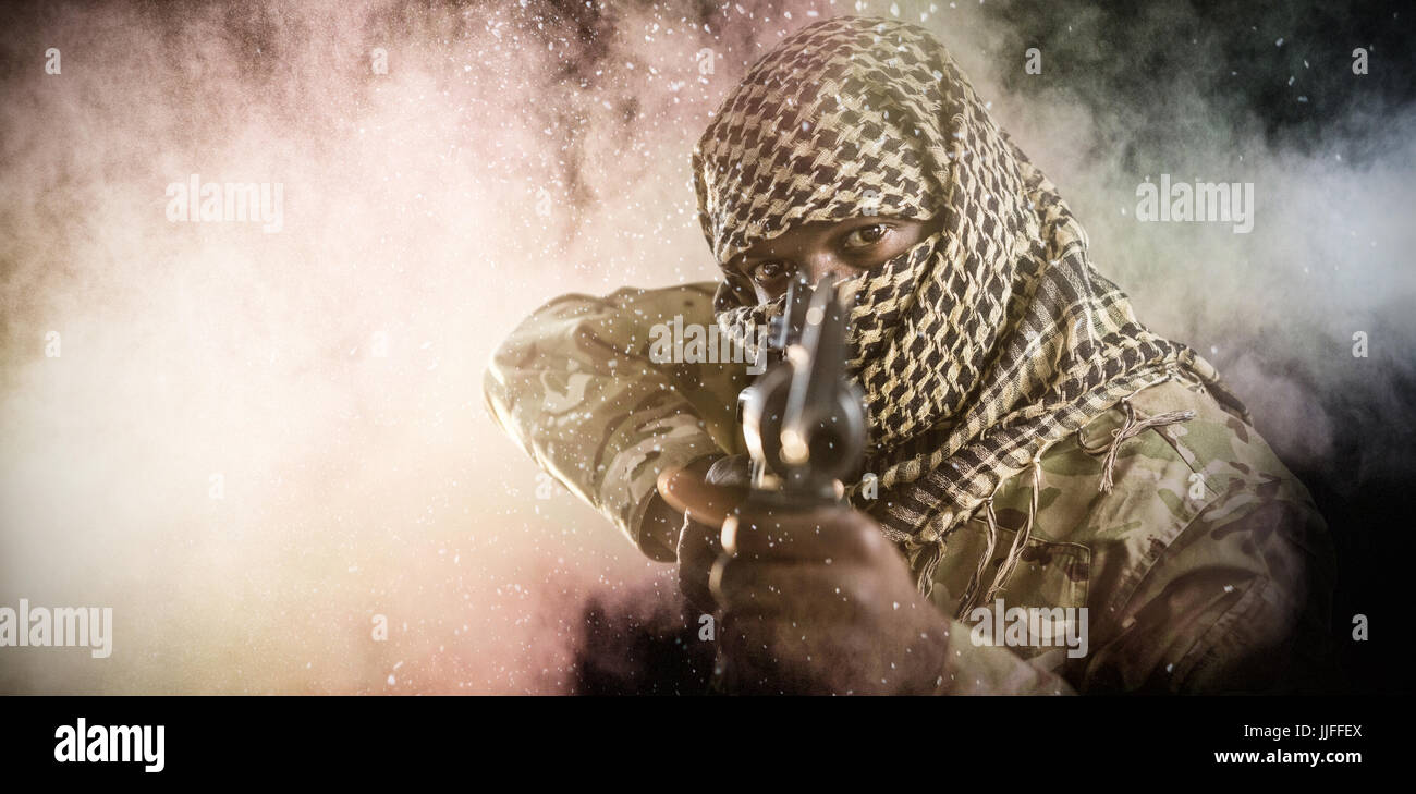 Portrait of face covered soldier aiming with rifle against black Stock ...