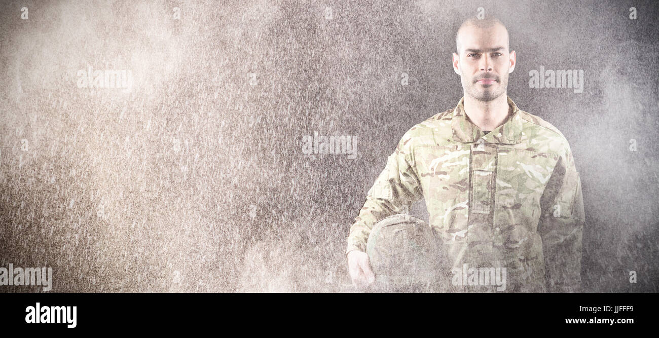 Portrait of confident soldier with helmet against black wall Stock ...