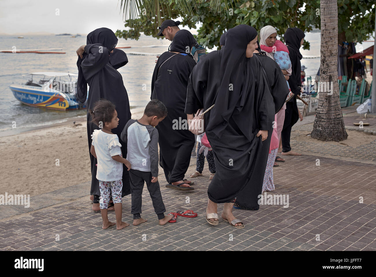 Arab women in traditional Chador attire at the beach. Saudi Arabia woman. Group Middle East females and family. Stock Photo