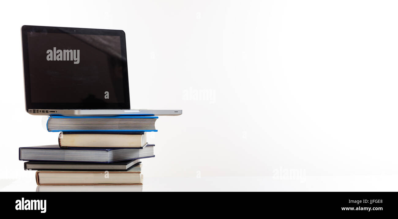 Education concept. Books stack and a laptop isolated on white background - copy space Stock Photo