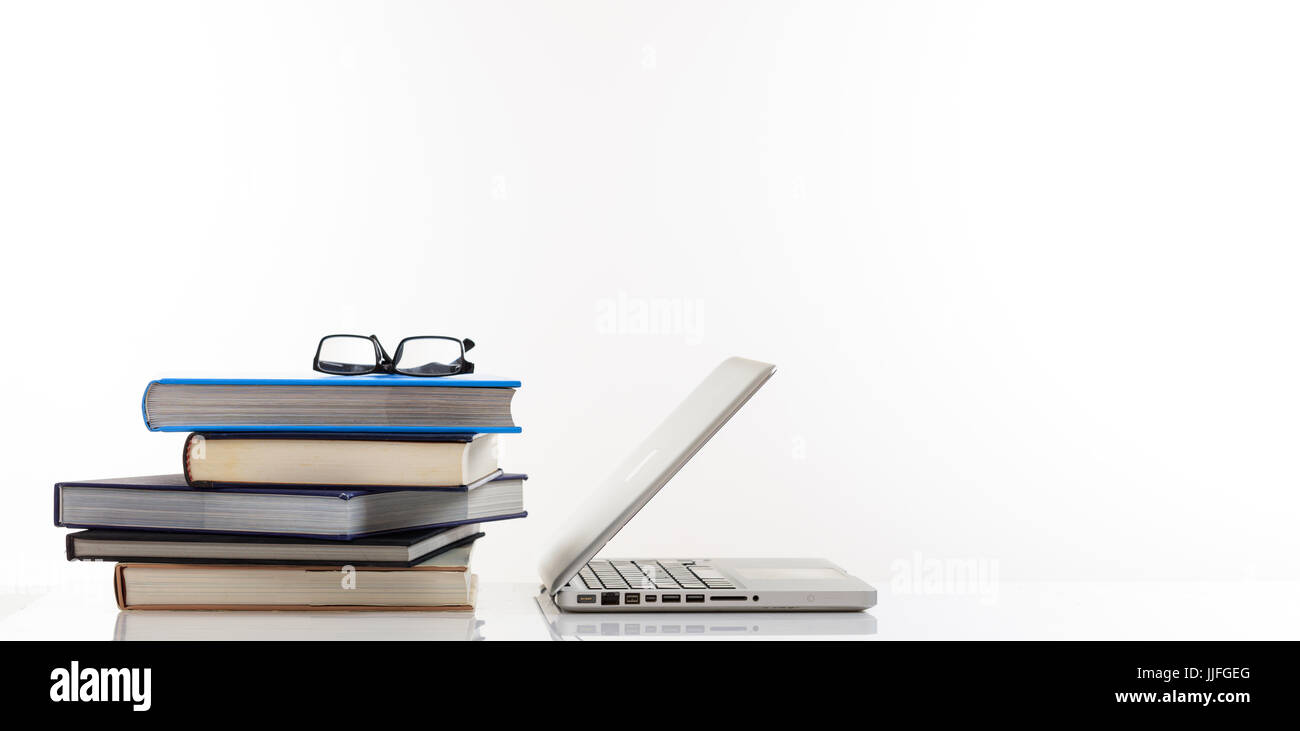 Education concept. Books stack and a laptop isolated on white background - copy space Stock Photo
