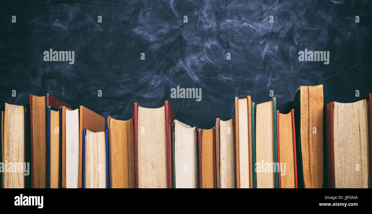 Old books on blackboard background - copy space Stock Photo