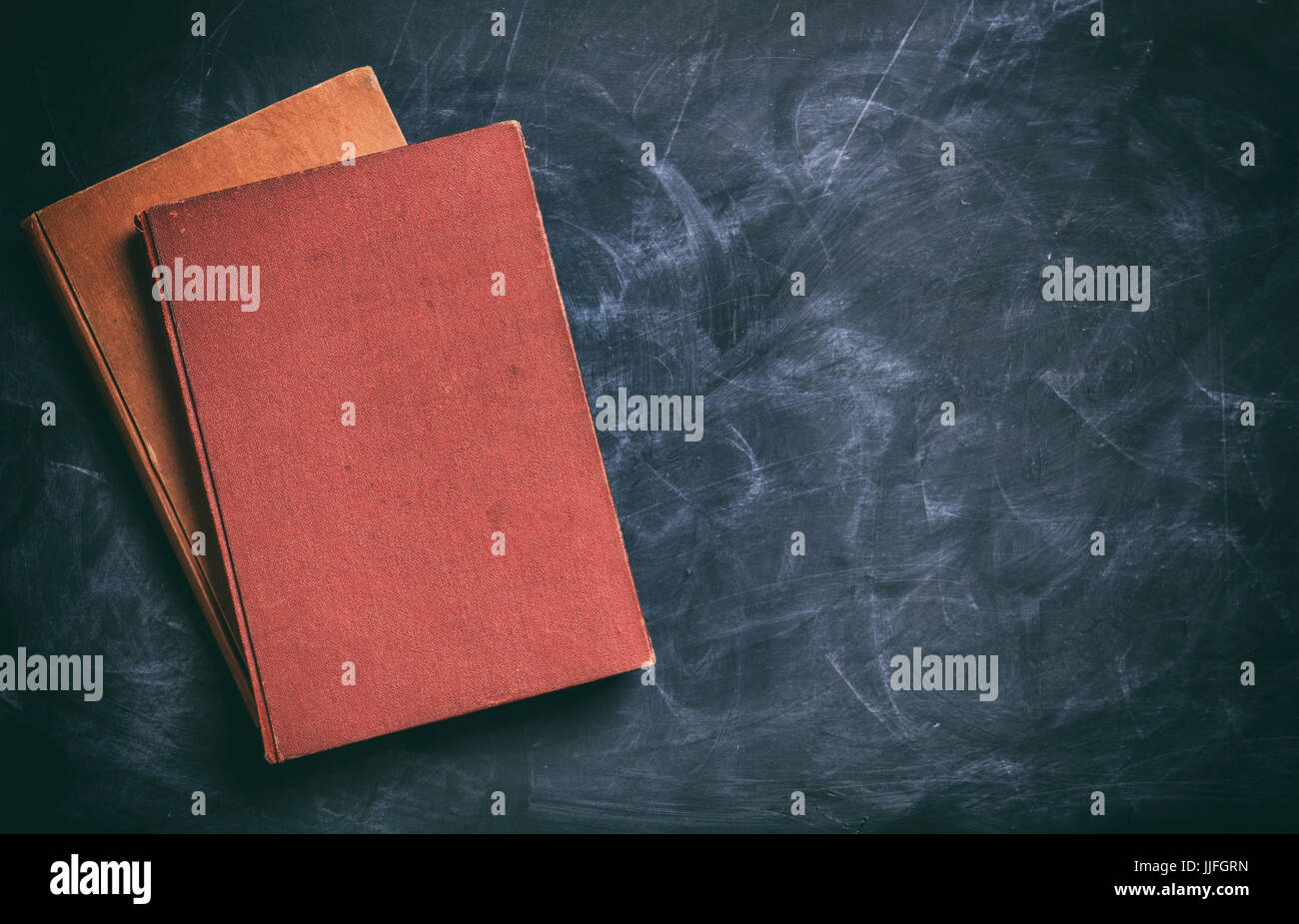 Old books on a blackboard background - copy space Stock Photo - Alamy