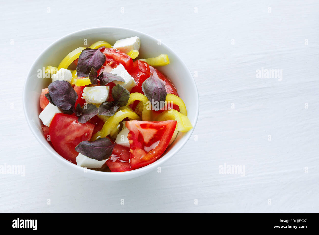 Vegetable salad with tomato pepper and basil at white background Stock Photo