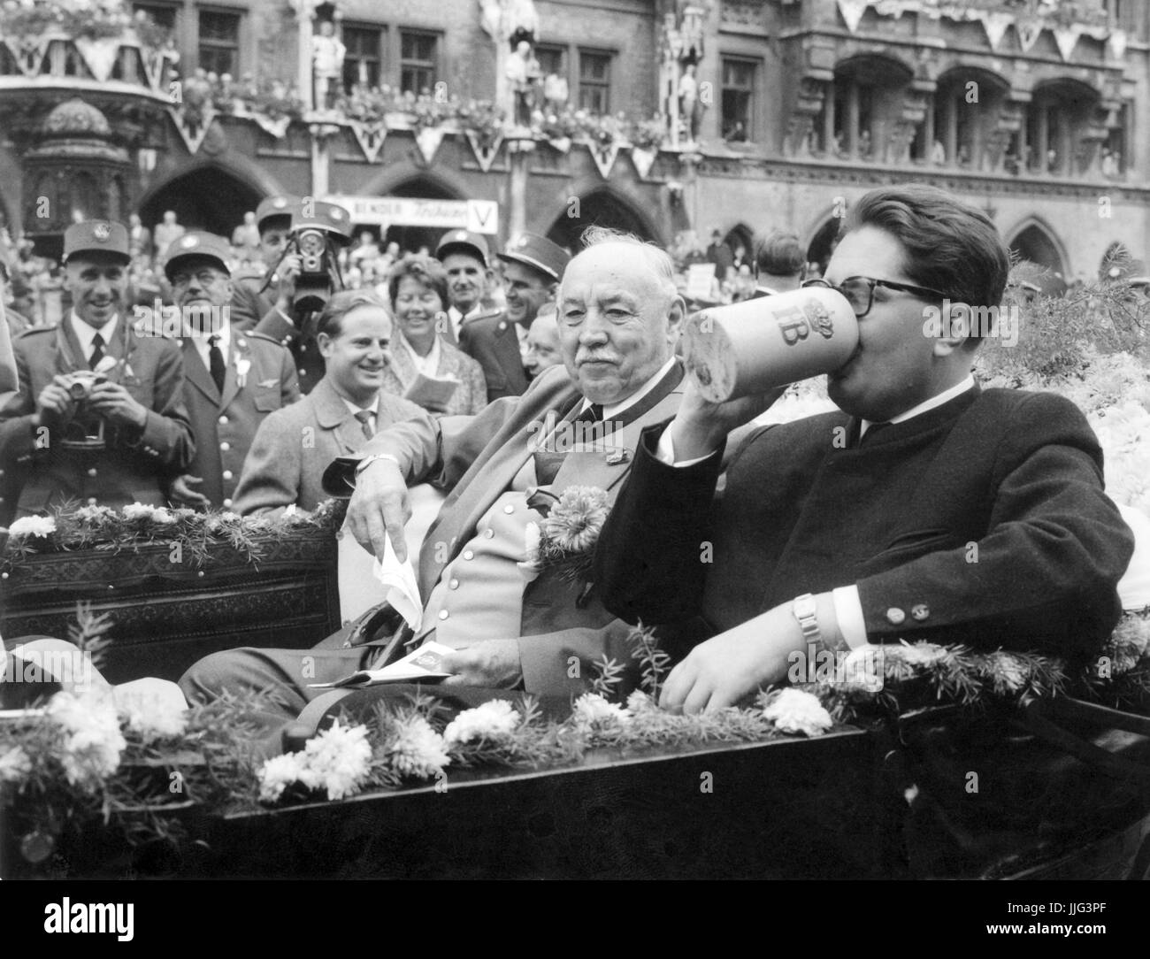 The new mayor of Munich, Hans-Jochen Vogel (r), refreshes himself with a sip of beer during the traditional parade at the Oktoberfest 1960.  Foto: Georg Göbel +++(c) dpa - Report+++ | usage worldwide Stock Photo