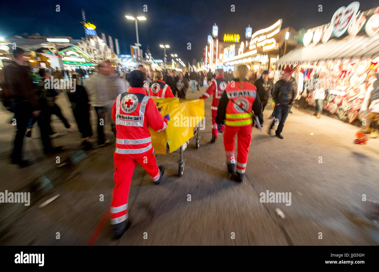Paramedics of the German Red Cross push a stretcher to a location at the 182nd Oktoberfest in Munich, Germany, 23 September 2015. 8,000 patients were treated at the first-aid station run by the German Red Cross last year, with 680 of them suffering from alcohol poisoning. The world's largest beer festival which will run until 04 October 2015 is expected to attract some six million visitors from all over the world this year. Photo: MATTHIAS BALK/dpa | usage worldwide Stock Photo