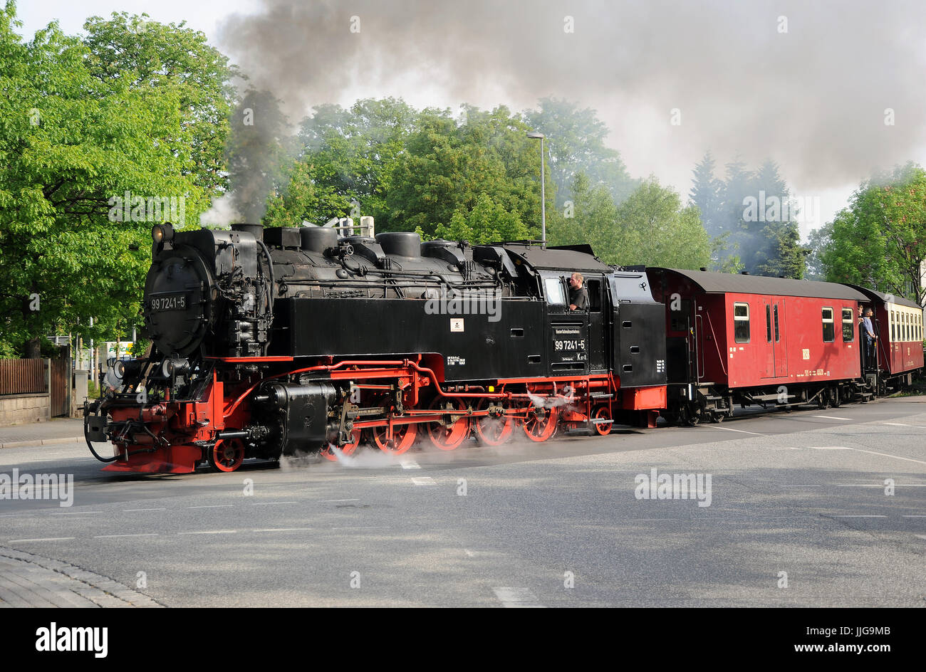 99 7241-5 traverses the level crossing at Wernigerode Westerntor with the 08:55 Wernigerode - Brocken train. Harzer Schmarlspurbahnen. Stock Photo