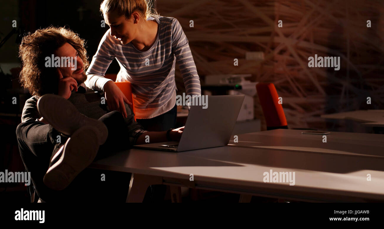Two young designers are working on a new project in the night office ...