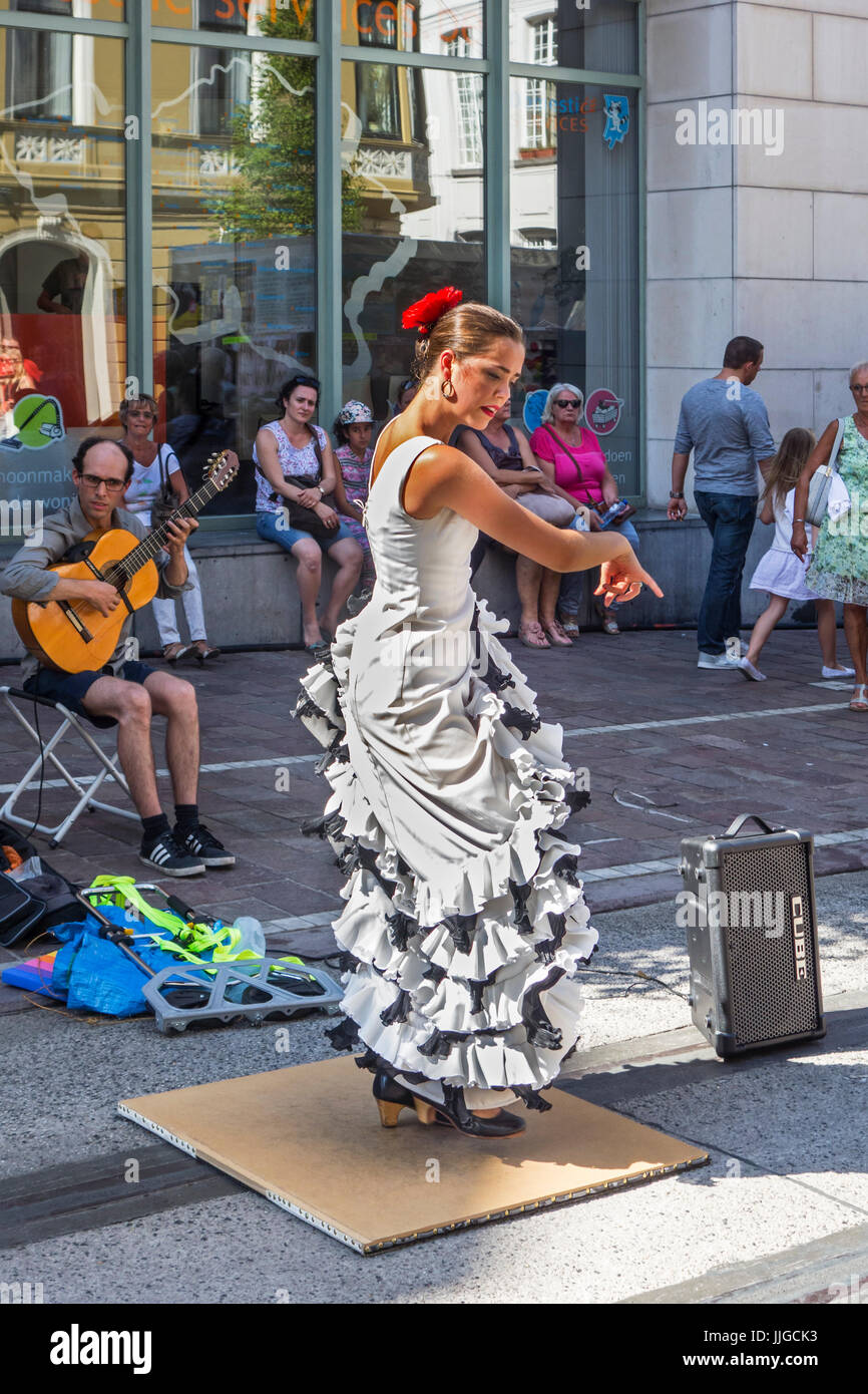 Guitarist and flamenco dancer with traditional white dress dancing as street performance during summer festivities Stock Photo