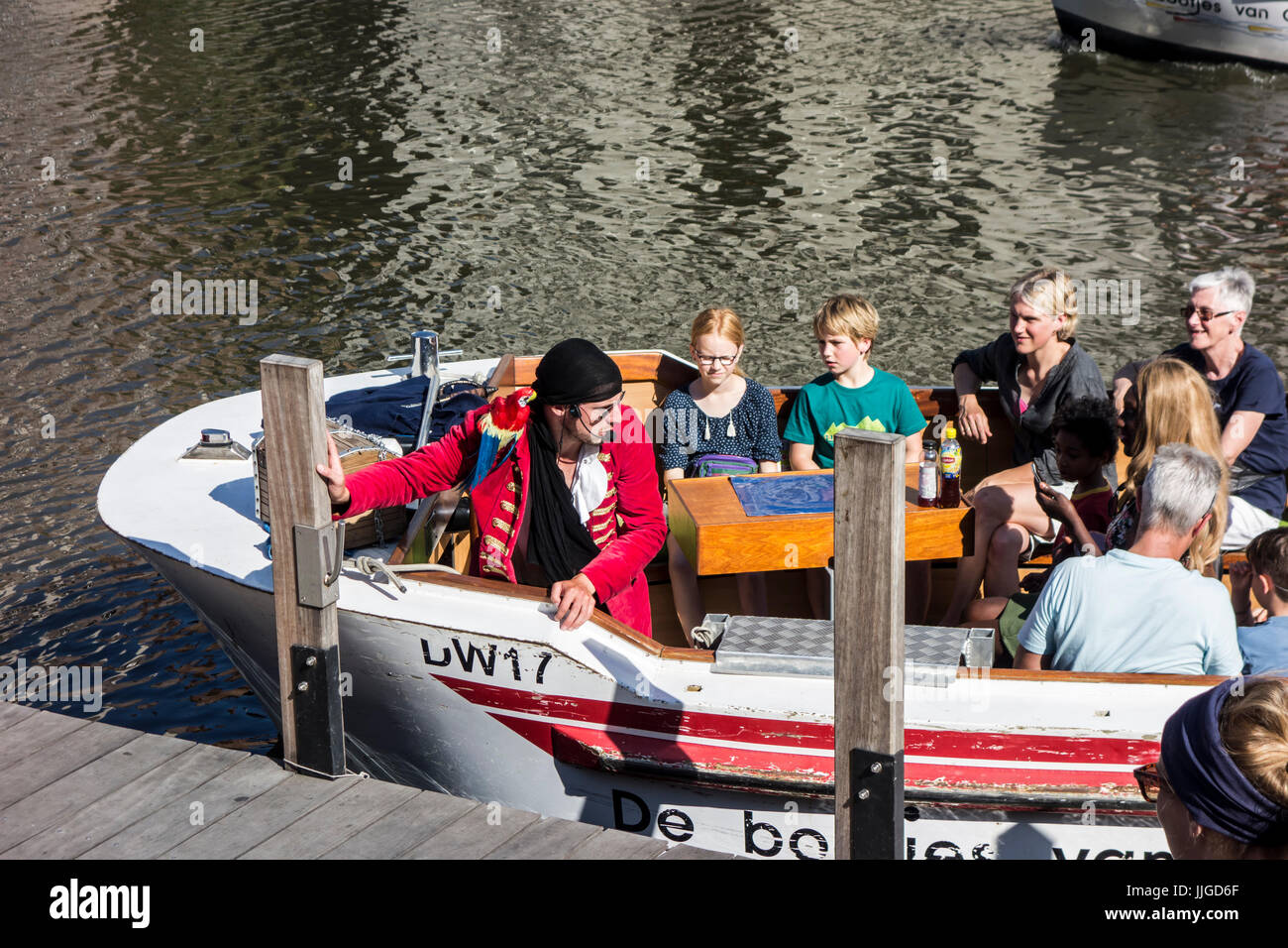 City guide dressed as pirate in boat on the river Leie / Lys guiding tourists during sightseeing trip in the town center of Ghent, Flanders, Belgium Stock Photo