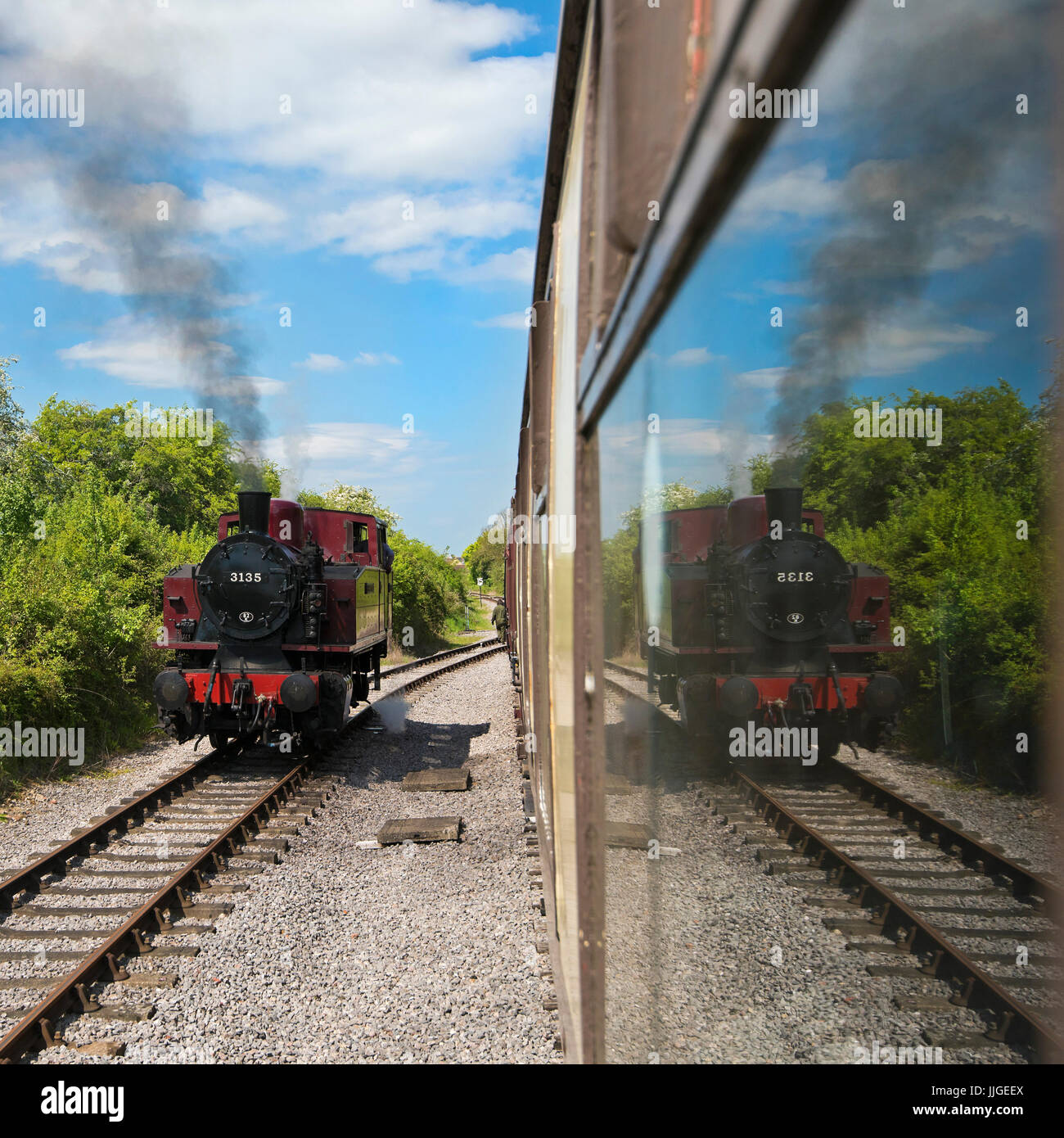 Square view of a steam locomotive reflected in carriage windows. Stock Photo