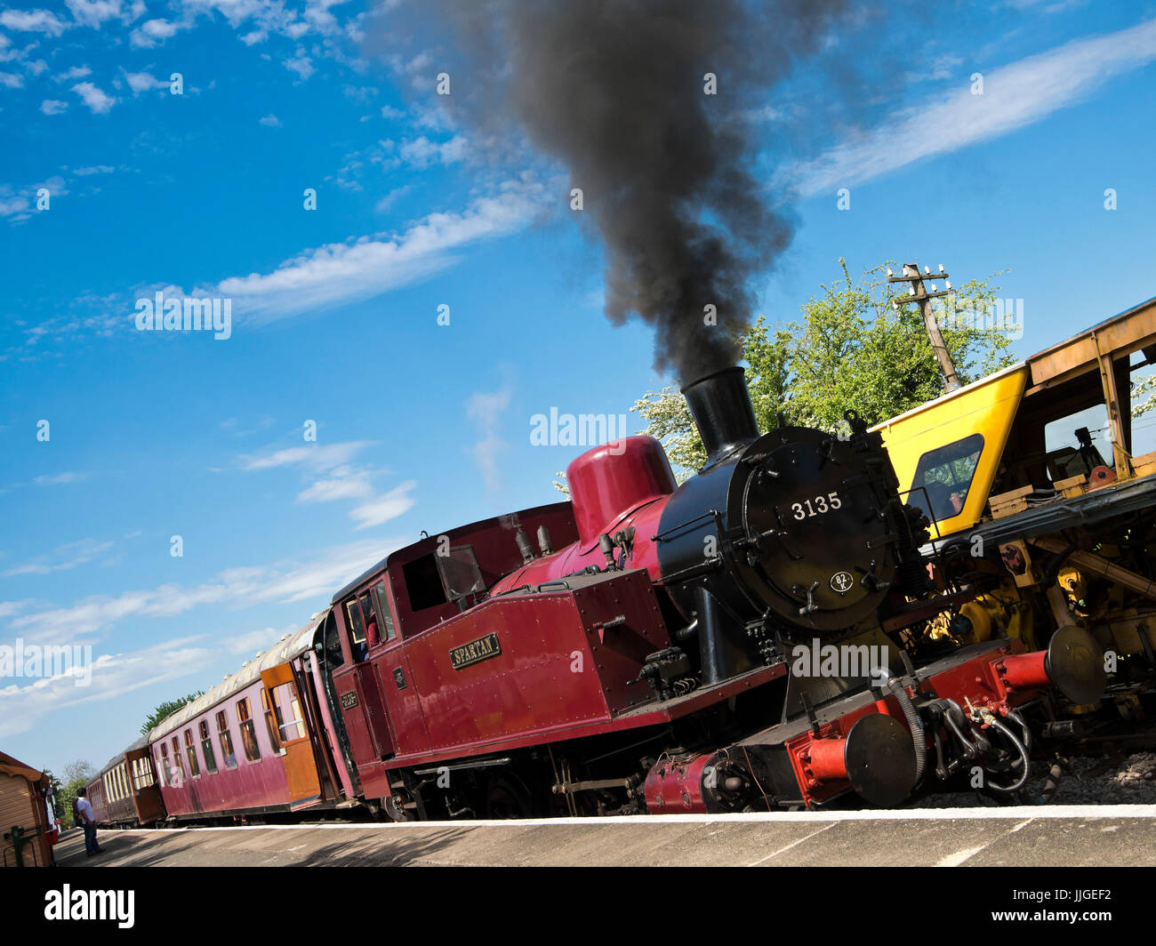 Horizontal view of a steam locomotive standing at a station platform. Stock Photo