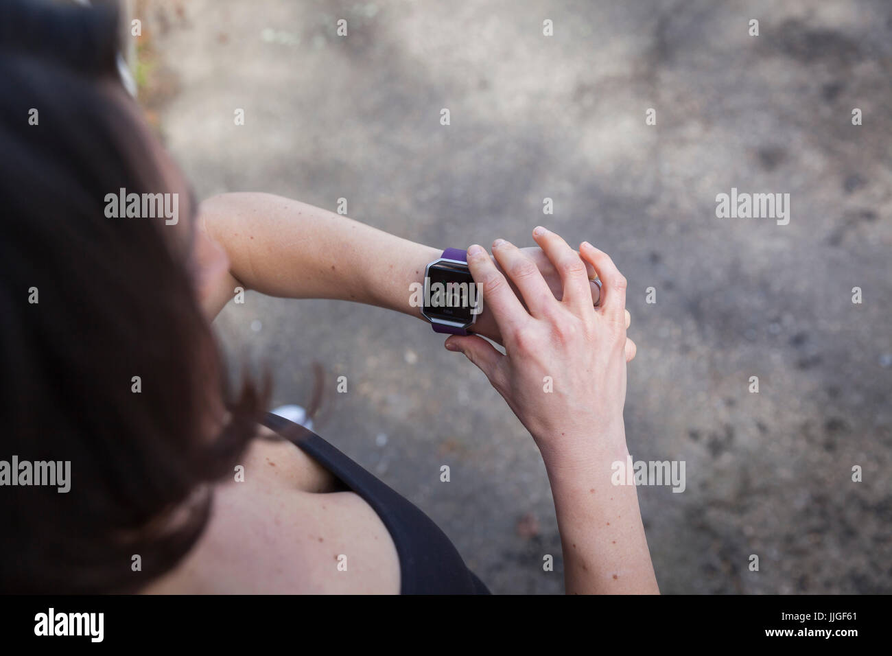 Woman checking her Fit Bit fitness tracker watch on her wrist. Stock Photo