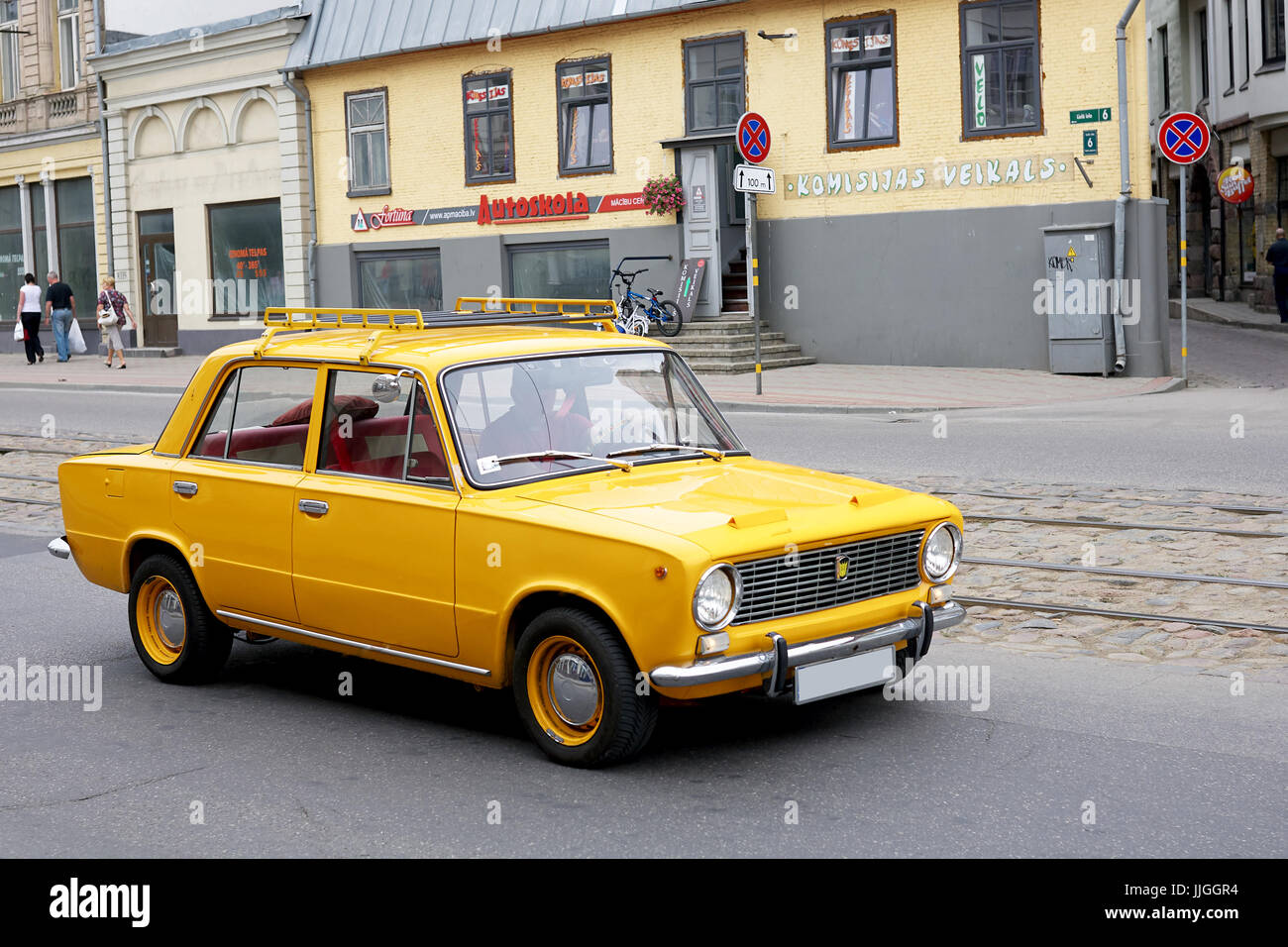 LIEPAJA, LATVIA - JULY 12 2012: Yellow russian soviet car driving on the city street Stock Photo