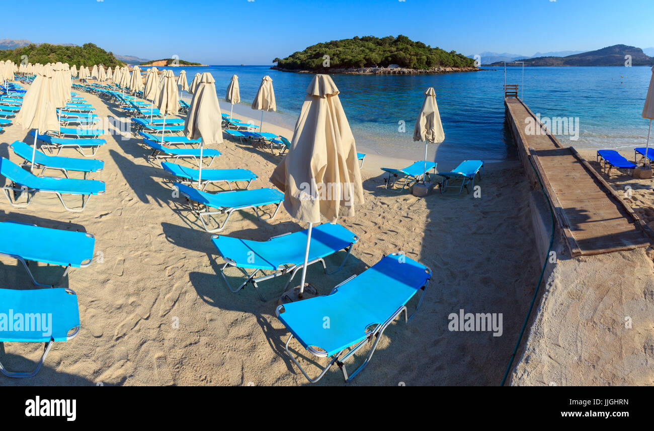 Summer morning sandy Ksamil Beach with sunbeds and sunshades (Albania ...