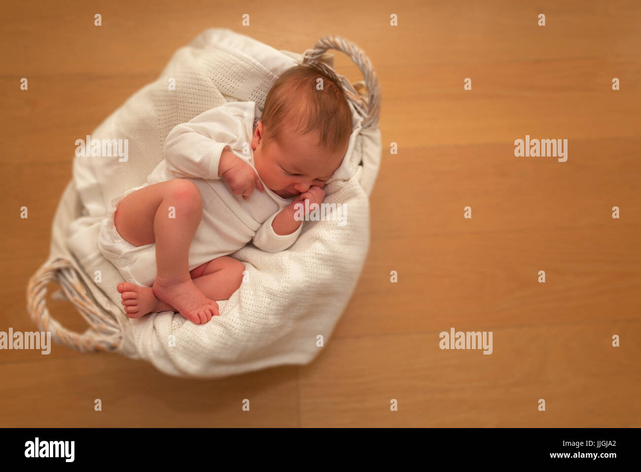 Newborn baby boy sleeping in a basket Stock Photo