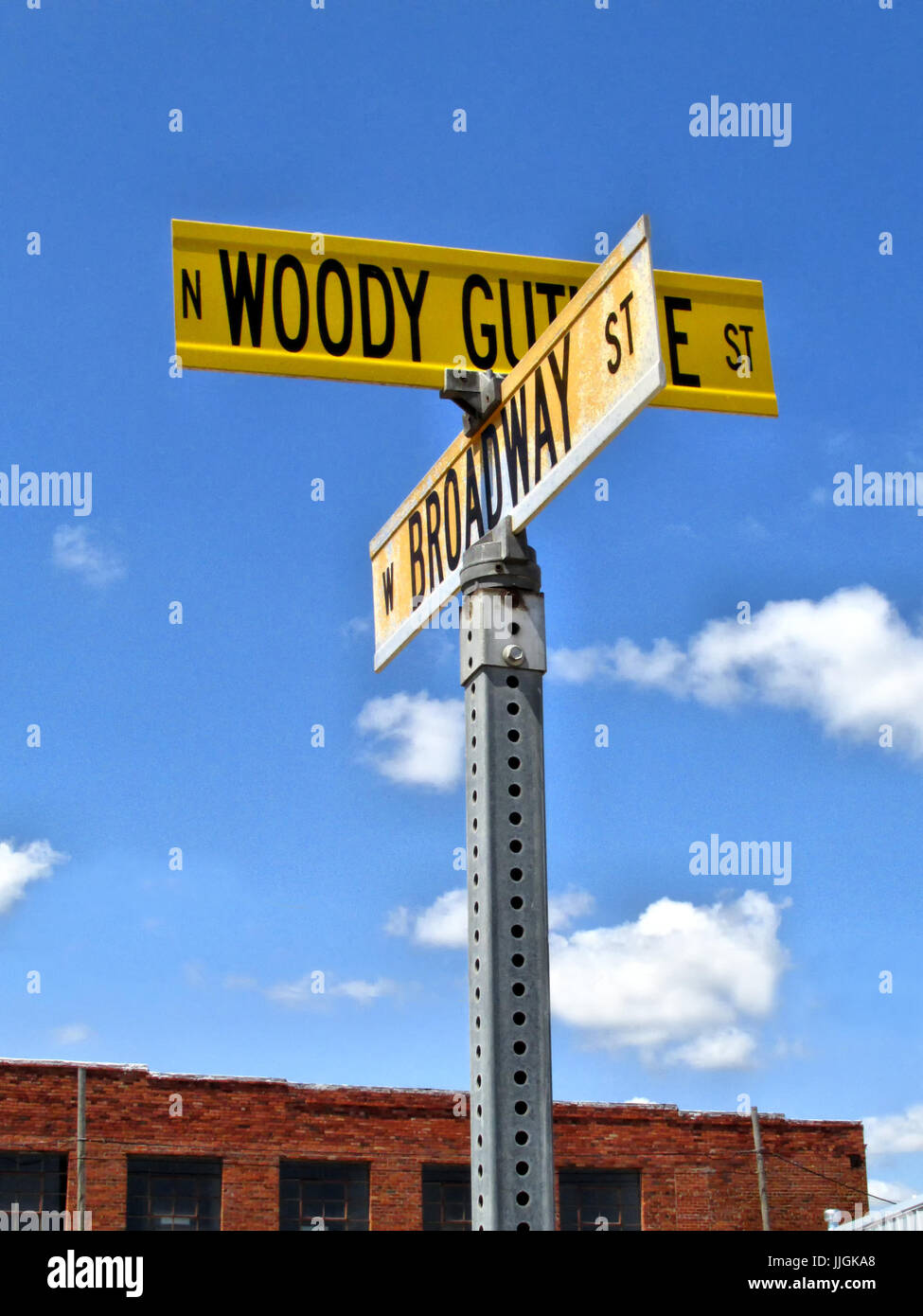 The street signs of Woody Guthrie Street and Broadway stand in downtown Okemah Oklahoma. Stock Photo