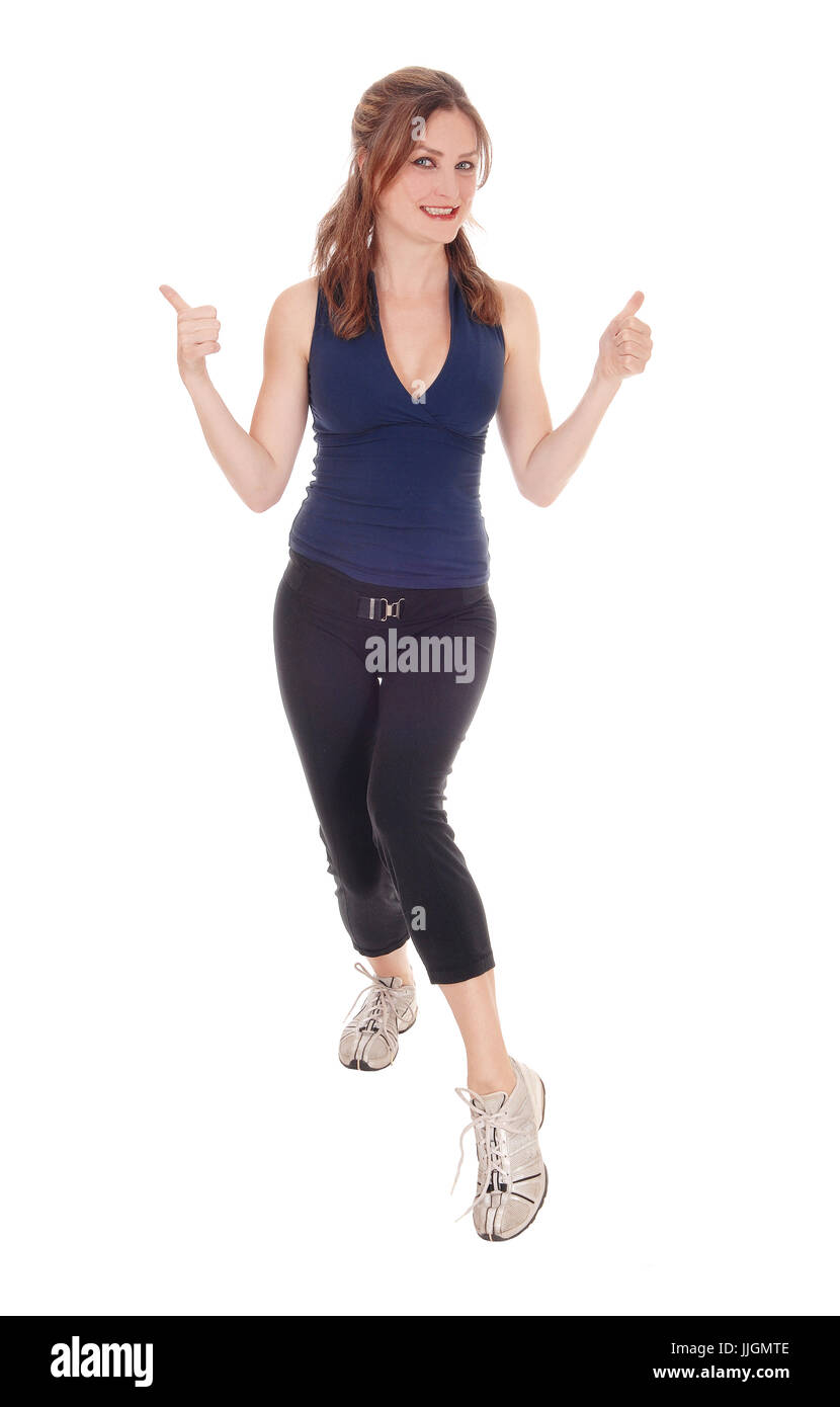 A beautiful young woman in a exercising outfit standing over white background with her thump up and smiling. Stock Photo