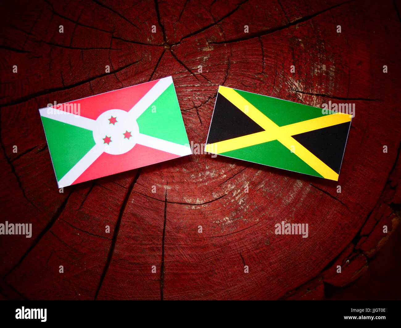 Burundi flag with Jamaican flag on a tree stump isolated Stock Photo